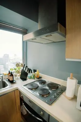 a kitchen with a stove with a sink and a window at Cozy and Spacious Studio at SOMA BGC Near SM Aura and Bonifacio High Street in Manila