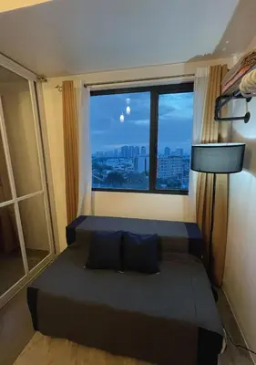 a bedroom with a bed and a large window at The Cozy Corner in Manila