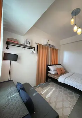 a bedroom with two beds and a couch in it at The Cozy Corner in Manila