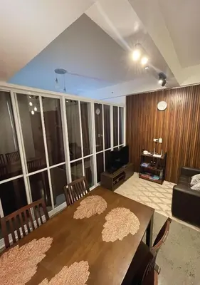 a living room with a table and chairs and a television at The Cozy Corner in Manila