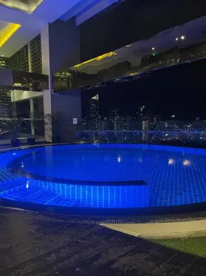 a large swimming pool with blue lights in a building at Spacious Unit in Gramercy Makati in Manila