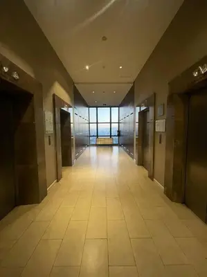 an empty hallway in a building with a large window at Spacious Unit in Gramercy Makati in Manila