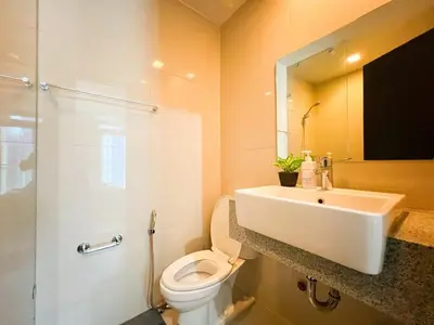 a bathroom with a sink and a toilet and a mirror at Luxury BGC Condo Near Uptown,Grand Hyatt #upt219k in Manila