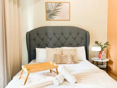 a bed with a black headboard and a wooden tray on it at Luxury BGC Condo Near Uptown,Grand Hyatt #upt219k in Manila