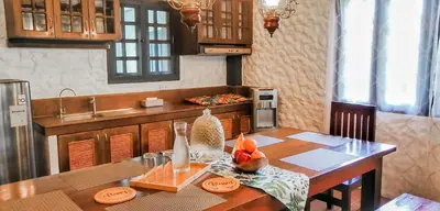 a kitchen with a wooden table with a counter top at Kasa Silang by Araw Residences in Cavite