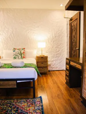 a bedroom with a bed and a table with a lamp at Kasa Silang by Araw Residences in Cavite