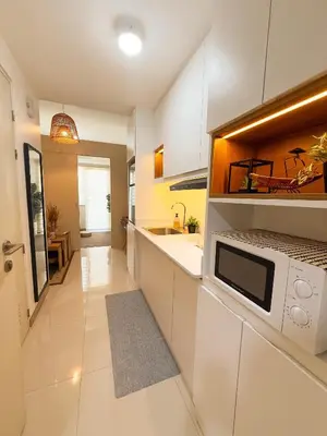 a kitchen with white cabinets and a microwave at Natural Haven at South in Manila