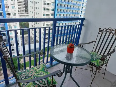 a glass table and two chairs on a balcony at Jericho's Place in Manila