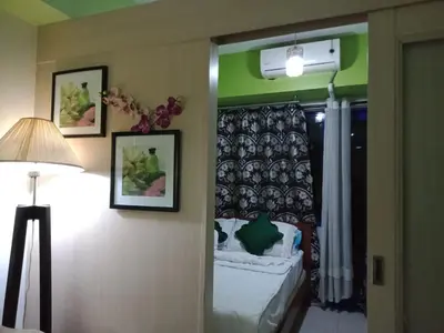 a bedroom with a bed and a lamp and a window at Jericho's Place in Manila