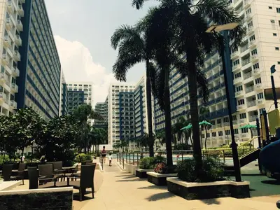 a city street with benches and palm trees and buildings at Jericho's Place in Manila