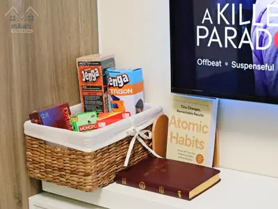 a basket of snacks and books on a shelf next to a tv at Cozy Vibrant Staycation Netflix Wifi Mandaluyong in Manila