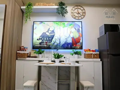 a large screen tv on a wall with a table at Cozy Vibrant Staycation Netflix Wifi Mandaluyong in Manila