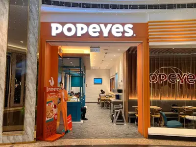 a person standing in front of a popeyes store at Cozy Vibrant Staycation Netflix Wifi Mandaluyong in Manila