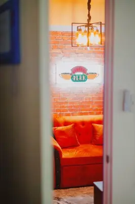 a couch against a brick wall with a sign on it at The One with Purple Apartment in Manila