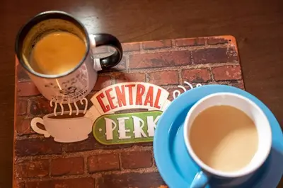 a cup of coffee sitting on a table with a plate at The One with Purple Apartment in Manila