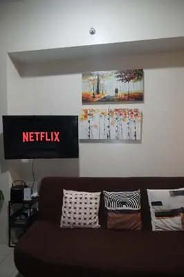 a living room with a couch and a sign on the wall at Cluster 2, 81 Newport Blvd Near NAIA T3 in Manila