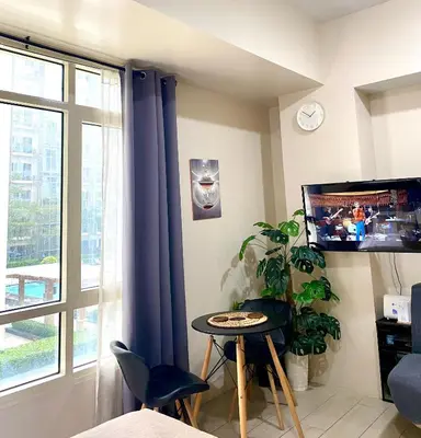 a living room with a table and a tv at Cluster 2, 81 Newport Blvd Near NAIA T3 in Manila