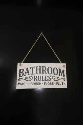 a sign that reads bathroom commissioner hanging on a wall at Cluster 2, 81 Newport Blvd Near NAIA T3 in Manila
