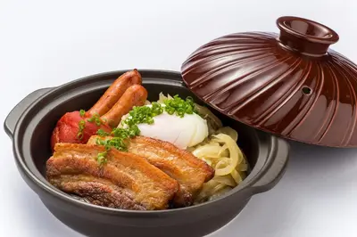 a black bowl of food with carrots and meat at City of Dreams - Nobu Hotel Manila in Manila