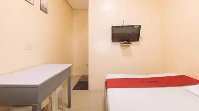 a hospital room with a desk and a tv on the wall at RedDoorz at LYOTO Bed and Breakfast near NAIA Terminal in Manila