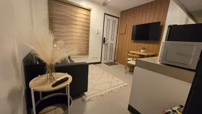 a living room with a television and a remote control on a stool at Flat 35, Unit D in Manila