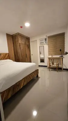 a bedroom with a bed and a table in it at Flat 35, Unit D in Manila