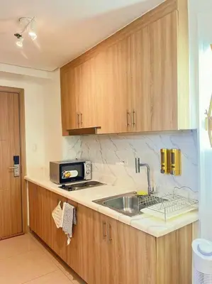 a kitchen with a sink and a microwave at 1BR Balcony Luxury Condo Shore 2 Near MOA & NAIA in Manila