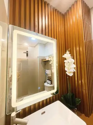 a bathroom with a sink and a mirror and a toilet at 1BR Balcony Luxury Condo Shore 2 Near MOA & NAIA in Manila