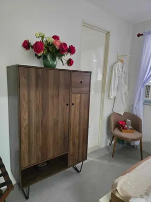 a room with a dresser with a vase of flowers on it at Vintage charm meets modern relaxation near Araneta in Manila