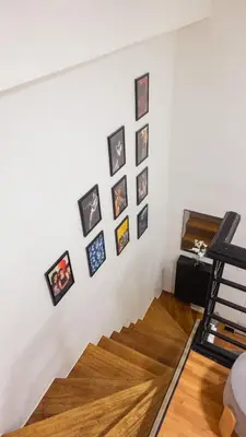 a room with a white wall with pictures on it at Modern Condo for 6, with Kitchen, Wi-Fi & Netflix, Near MRT Boni in Manila