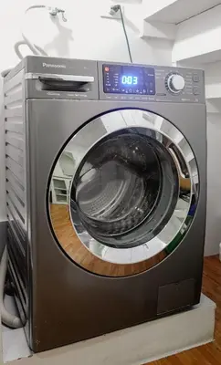 a washing machine is sitting on a counter at Modern Condo for 6, with Kitchen, Wi-Fi & Netflix, Near MRT Boni in Manila