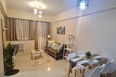a living room with a table and a couch at 1BR with Balcony Condo accross NAIA T3 in Manila