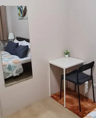 a table and a chair in a room with a bed at 1BR with Balcony Condo accross NAIA T3 in Manila