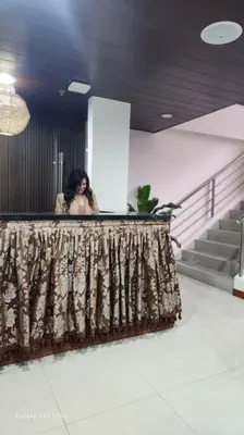 a woman standing behind a counter in a building at Playful comfort and Serene relaxation in Cubao in Manila
