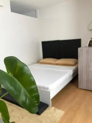 a white bed in a room with a green plant at Metro Suites in Anabu Primero