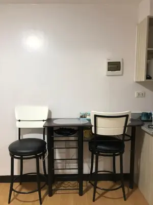 a kitchen with two chairs and a table in a room at Metro Suites in Anabu Primero