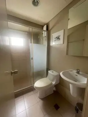 a bathroom with a toilet and a sink and a shower at Avida San lorenzo Tower 1 in Manila