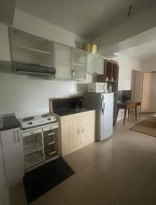 a kitchen with a stove and a white refrigerator at Avida San lorenzo Tower 1 in Manila