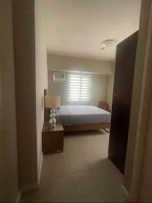 a bedroom with a bed and a window at Avida San lorenzo Tower 1 in Manila