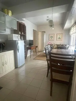 a kitchen and dining room with a table and a refrigerator at Avida San lorenzo Tower 1 in Manila