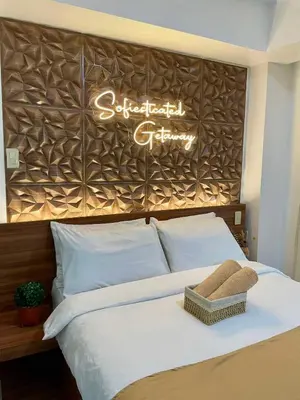 a bedroom with a bed with a sign on the wall at 1 Bedroom Azure Staycation Near NAIA in Manila