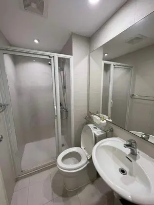 a bathroom with a shower and a toilet and a sink at 1 Bedroom Azure Staycation Near NAIA in Manila