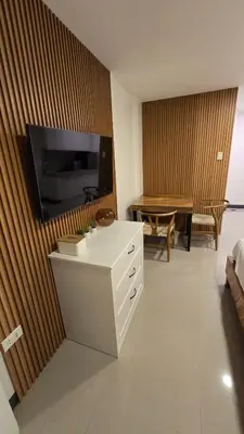a living room with a table and a tv on a wall at Flat 35, Unit 1F in Manila