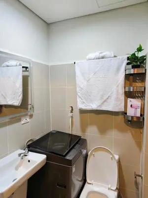 a small bathroom with a toilet and a sink at City Serenity Escape in Manila