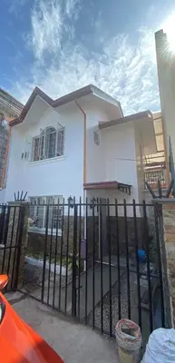 a white house with a fence in front of it at Cernardo's Staycation Place 1 near Enchanted Kingdom in Ibaba