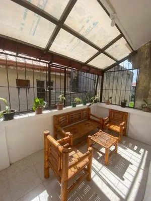 a conservatory with two benches and a table and windows at Cernardo's Staycation Place 1 near Enchanted Kingdom in Ibaba
