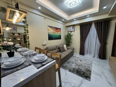 a living room with a couch and a table with plates at Kalizta Suites in Manila