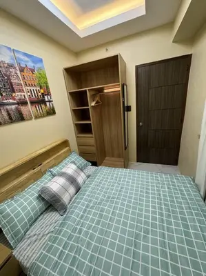 a bedroom with a bed with two pillows on it at Kalizta Suites in Manila