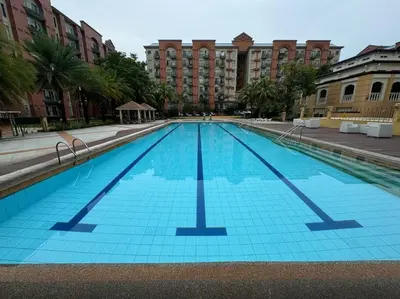 a large blue swimming pool with buildings in the background at Kalizta Suites in Manila
