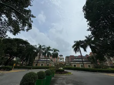 a building with palm trees in front of a street at Kalizta Suites in Manila